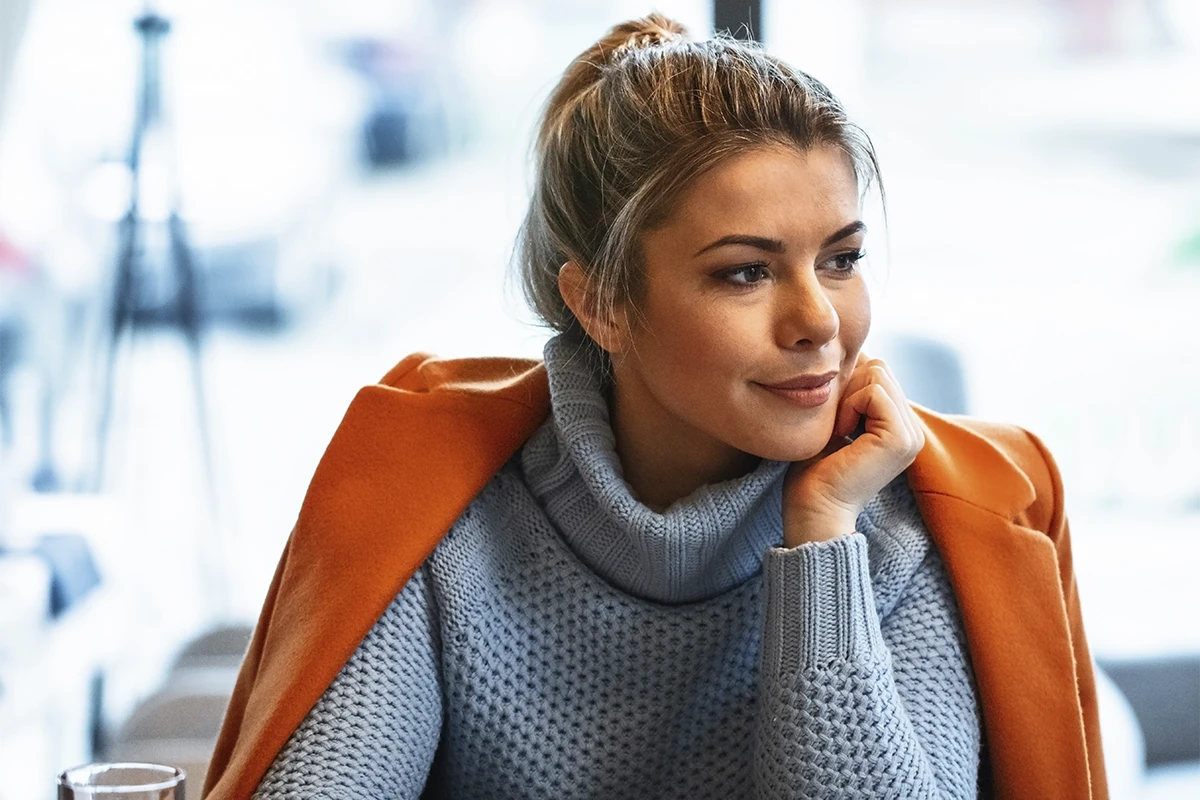 Woman in her 40s relaxing at home, representing hormone balance and wellness